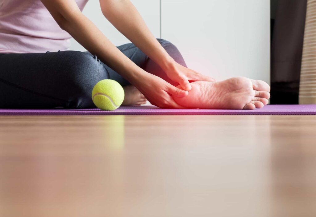 woman hands massage to her foot on yoga mat at hom 2021 08 30 23 33 50 utc scaled 1